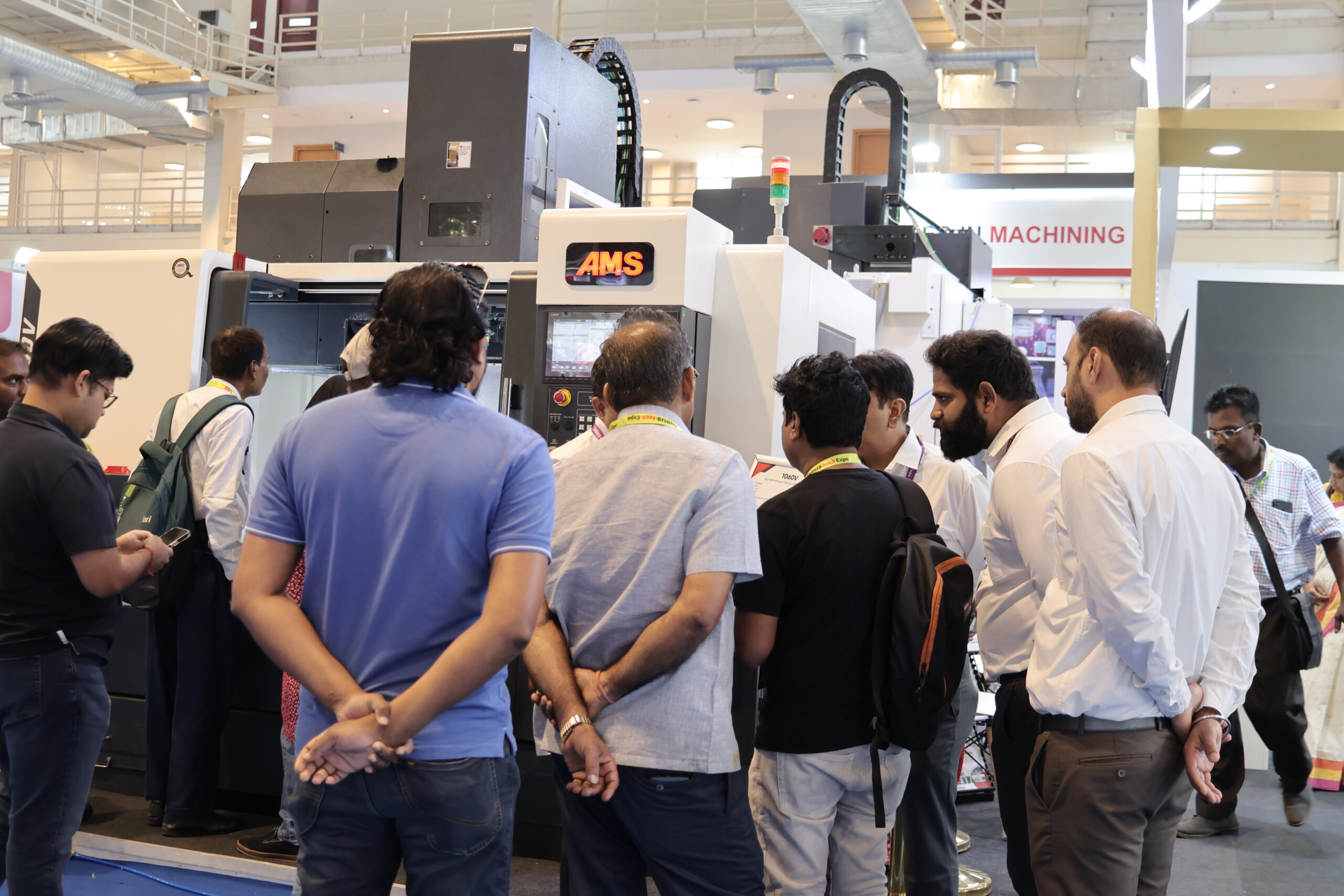Visitors watching AMS CNC machine demo live on floor