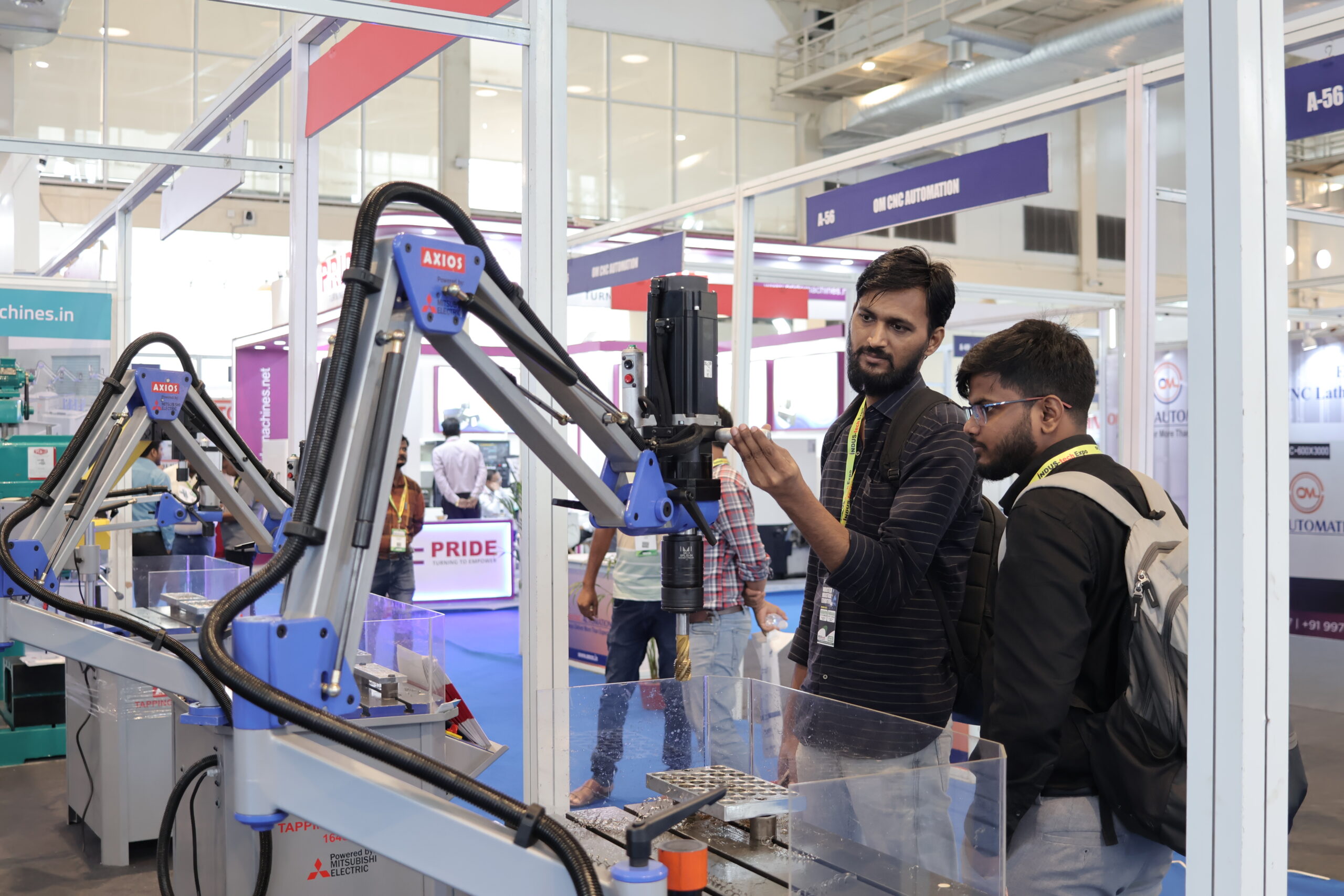 Visitors at Axios tapping machine demo live at stall