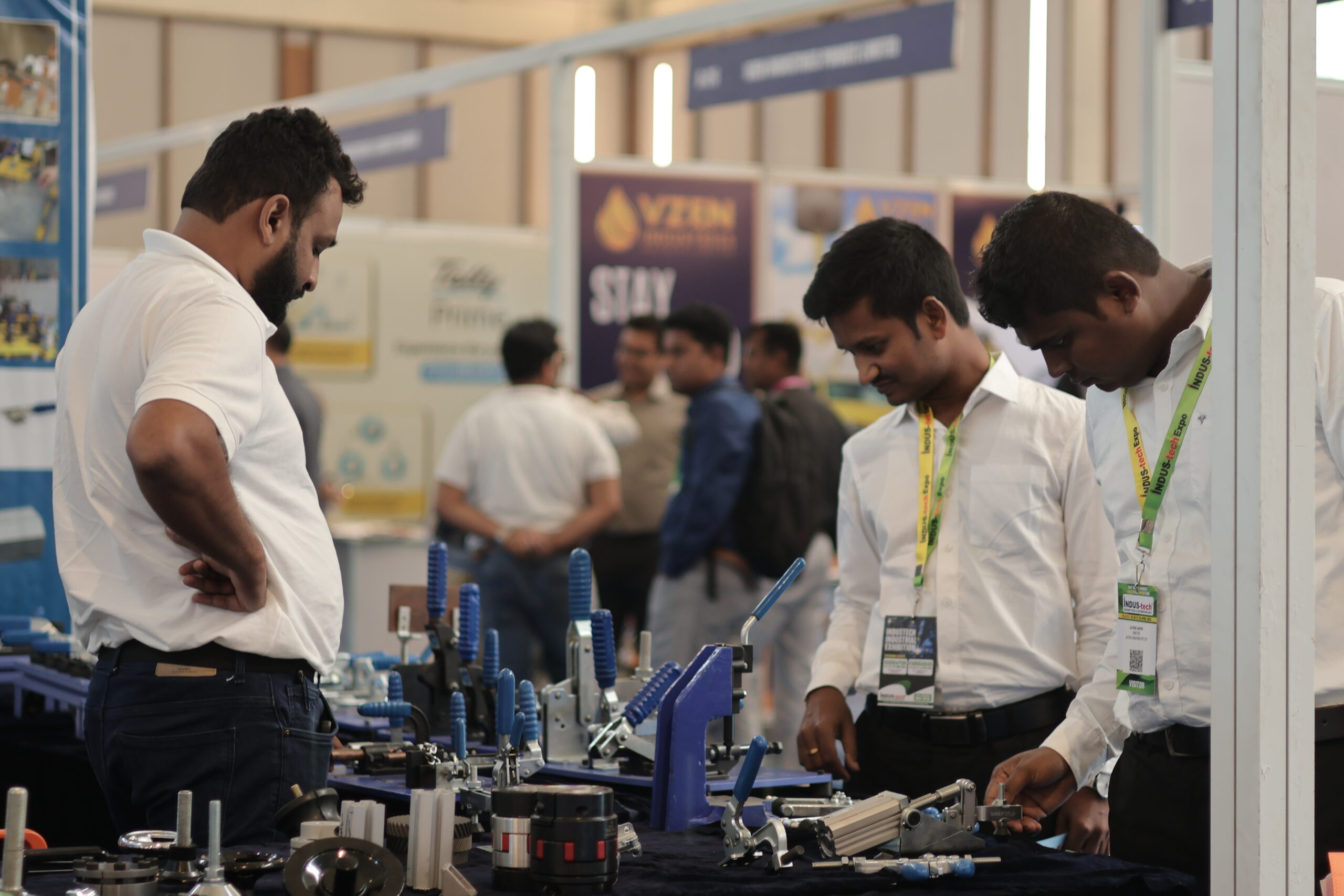 Visitors examining precision fixtures at exhibitor stall