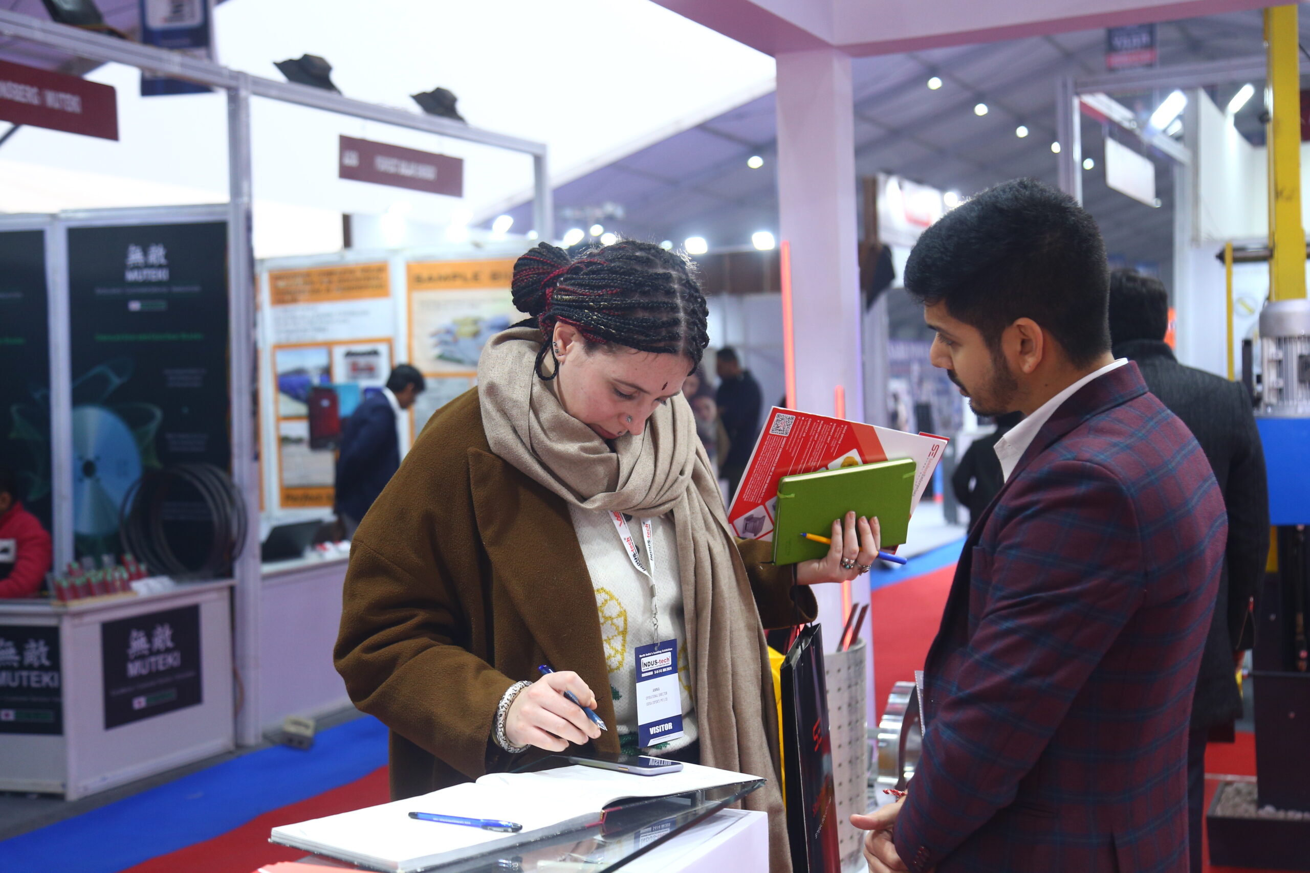 Visitor taking notes at exhibitor stall active interest