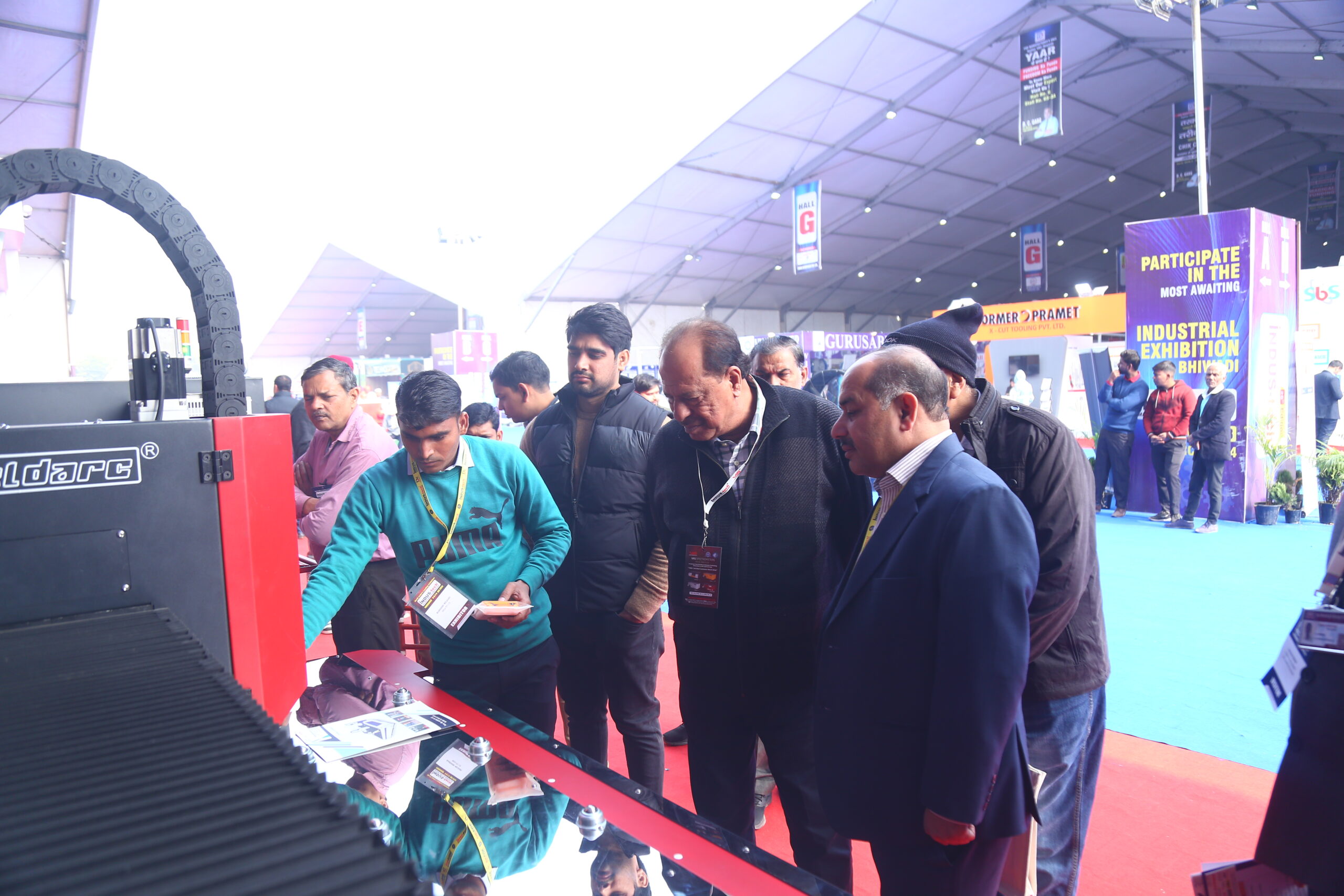Visitors examining Woldarc machine live demo at stall