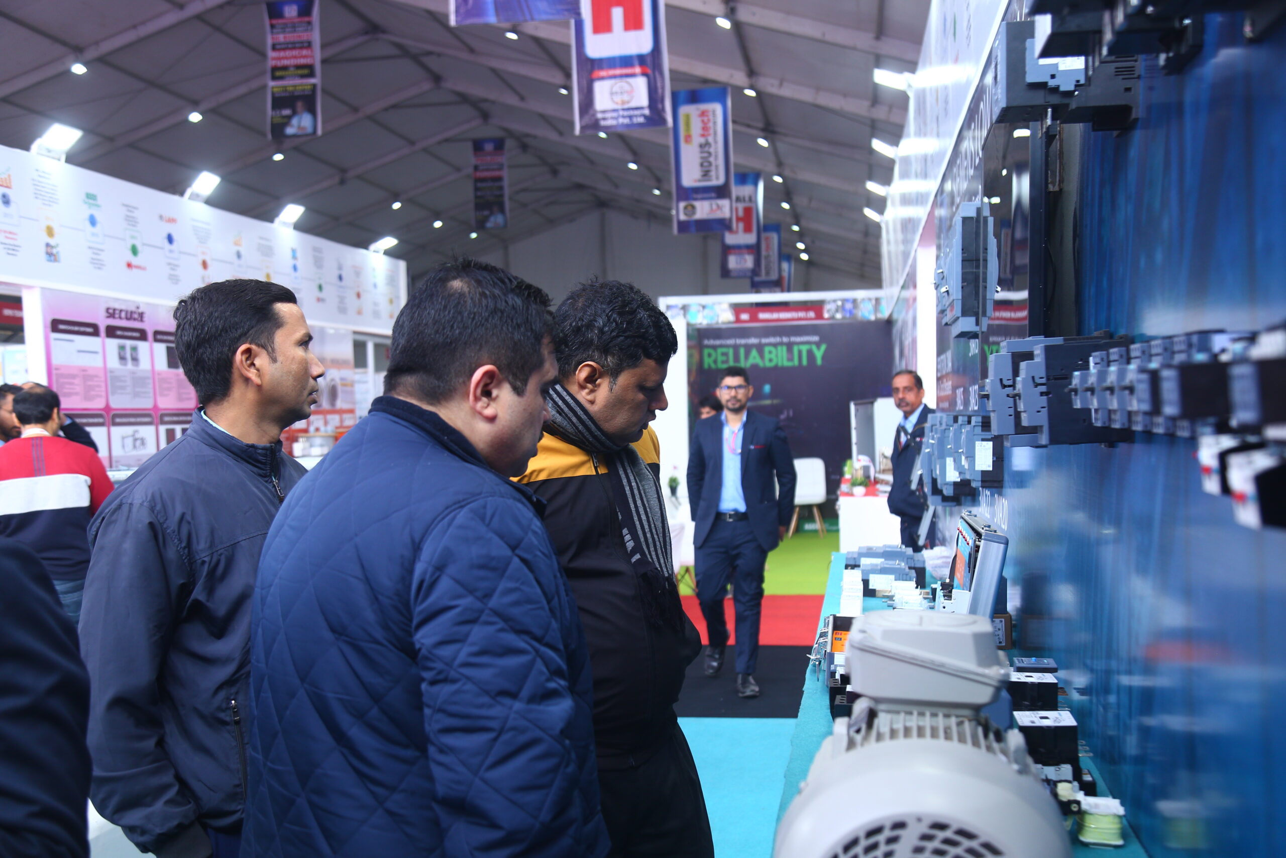 Visitors closely examining industrial motors at exhibitor stall
