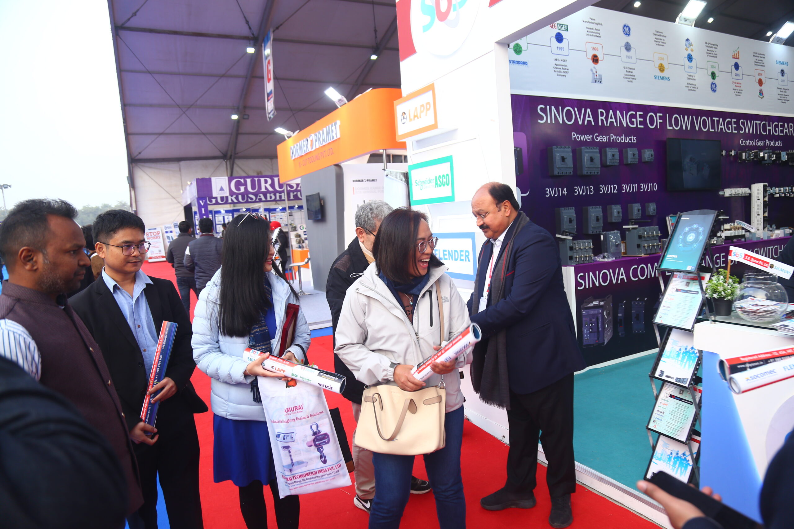 Exhibitor sharing brochures with visitors at Sinova stall