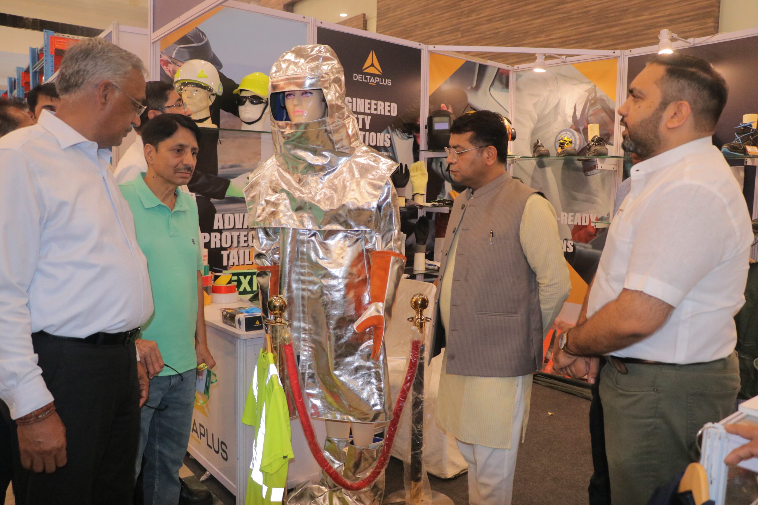 Visitors examining humanoid robot display at booth