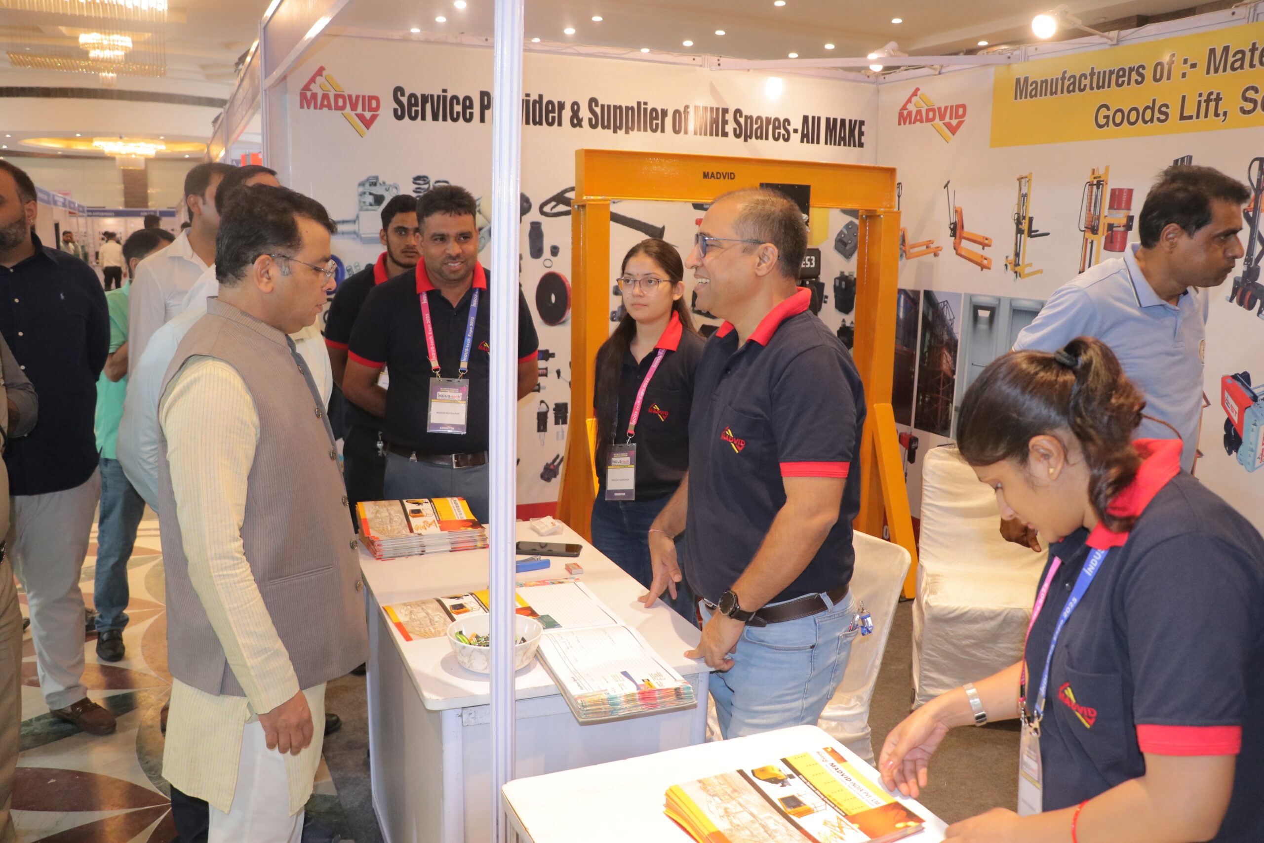 Group of visitors with brochures at exhibitor stall