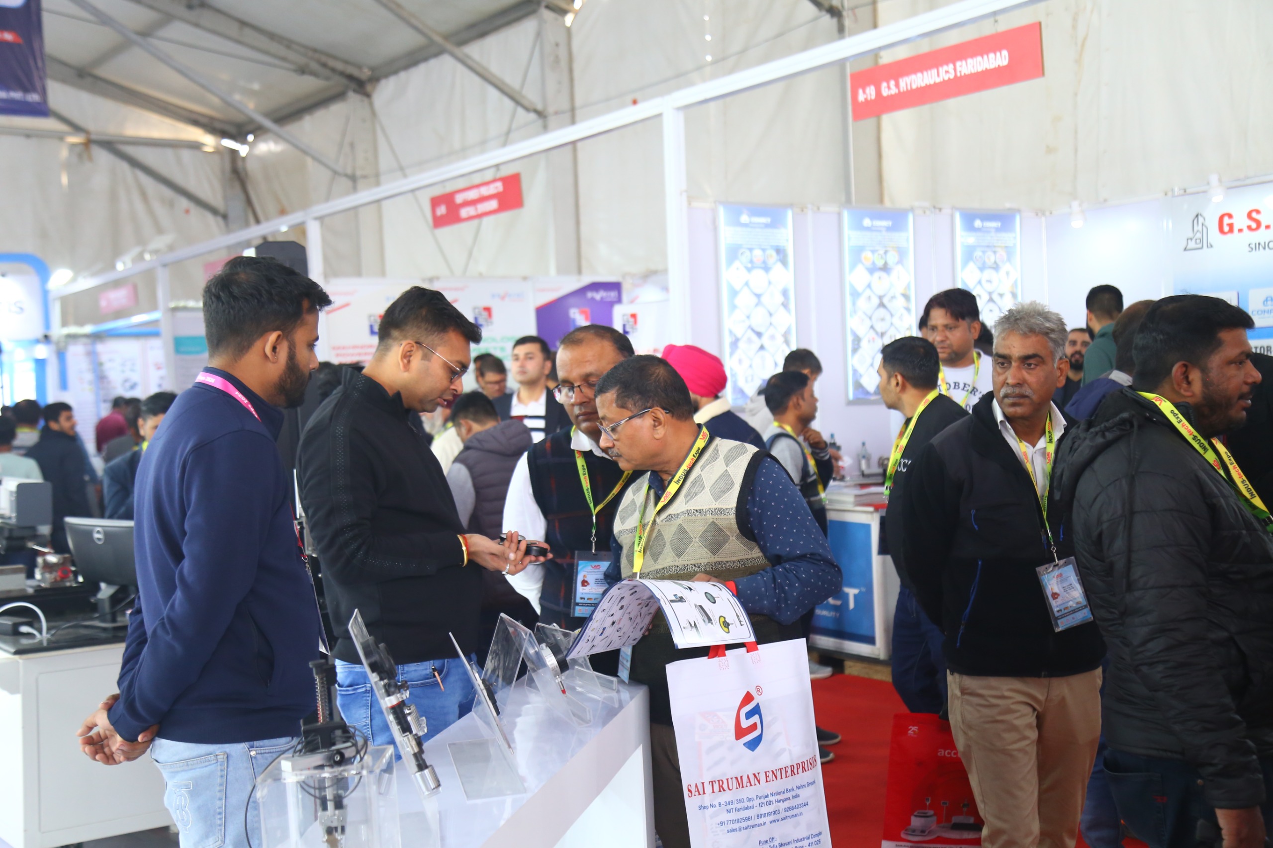 Visitors gathered at stall with exhibitor explaining product