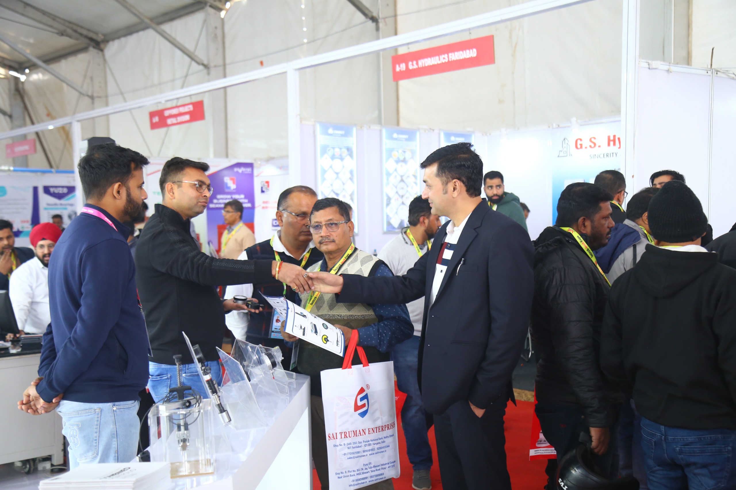 Exhibitor handing catalogue to visitor at GS Hydraulics stall