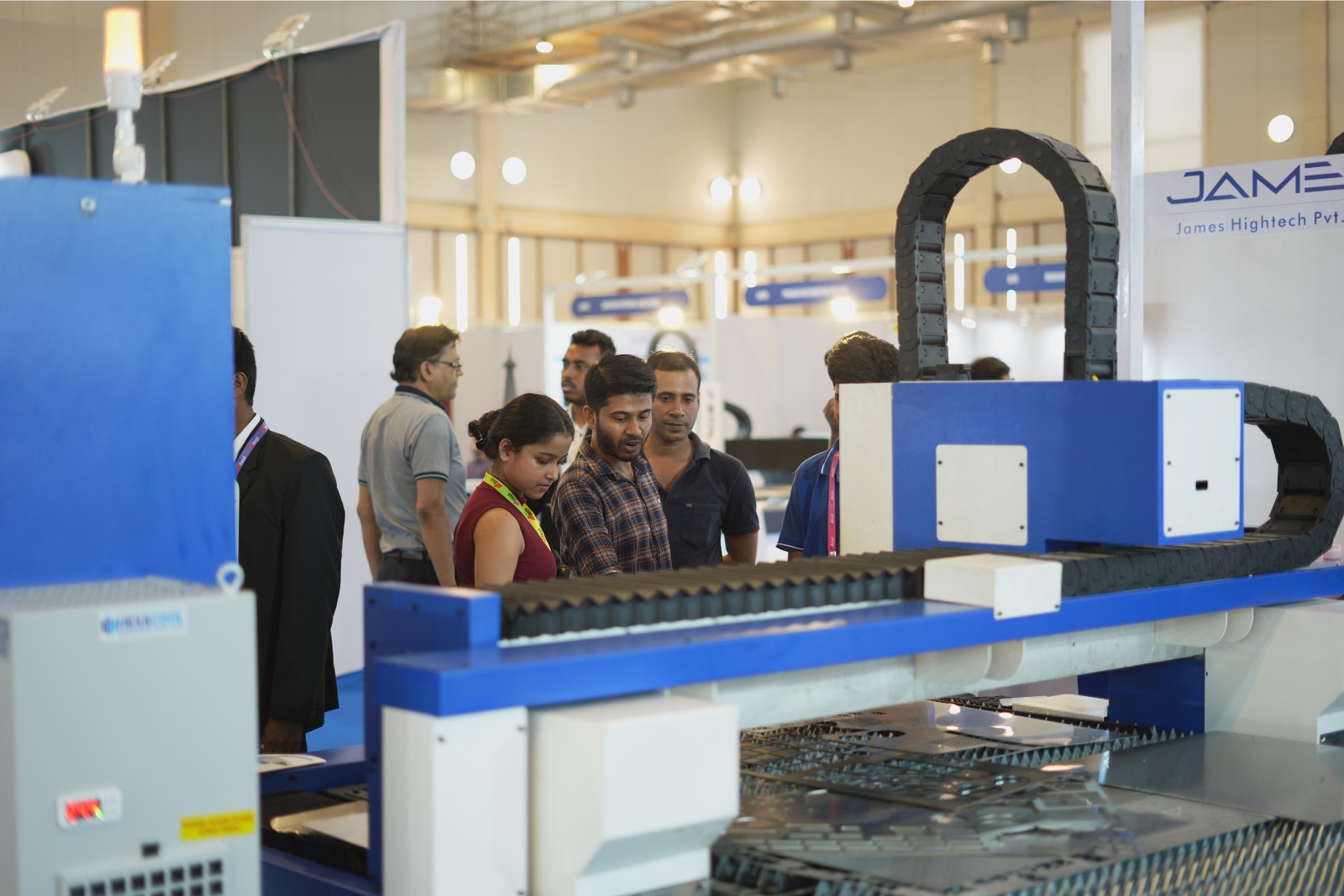 Visitors examining laser machine at James Hightech stall